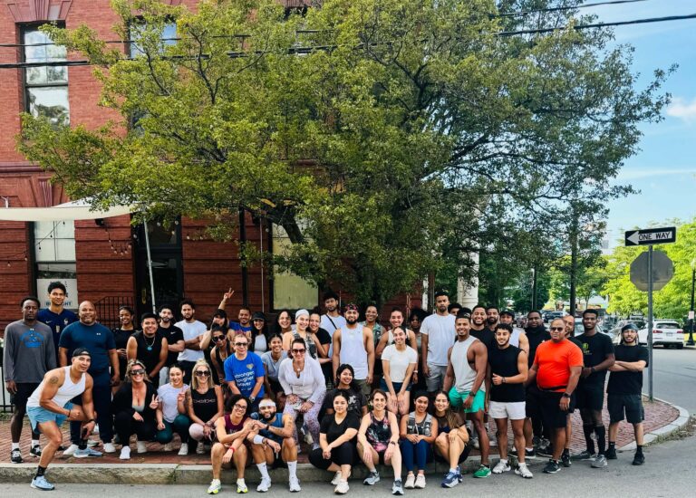 About fifty members of the 978 Run Club gathered on the sidewalk in front of a brick mill building